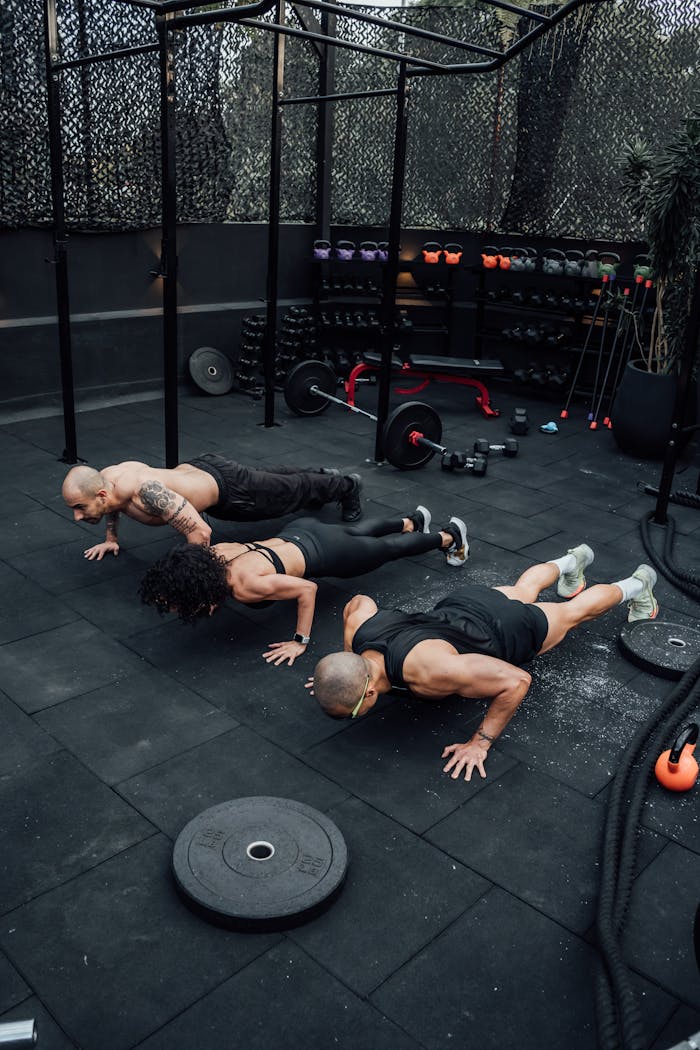 team-02 Three adults performing push-ups at an outdoor gym in Mexico City, showcasing strength and teamwork.